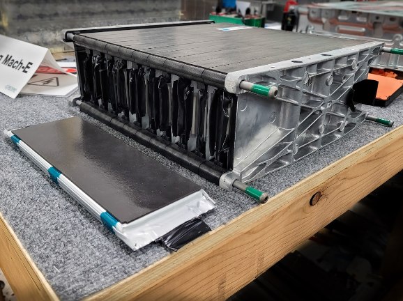 Ford Mach-E battery module with pouch-style cell on bench.