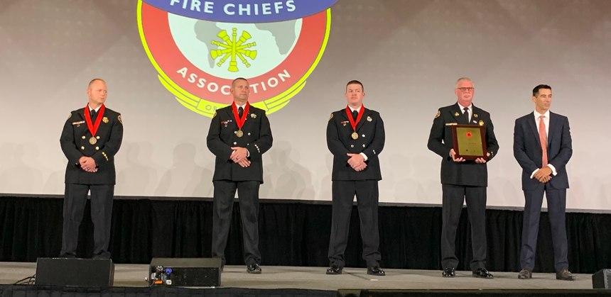 The three honorees stand with their chief, Allen Walls, and Chris Lonnett from Motorola Solutions.