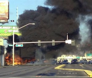 Smoke filled the sky after a fire tore through a minibus following a collision in Las Vegas on Saturday. (Associated Press)