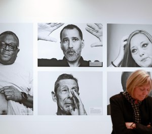CDC Museum Director Judy Gantt stands in front of portraits of members of the WTC Health Program at
