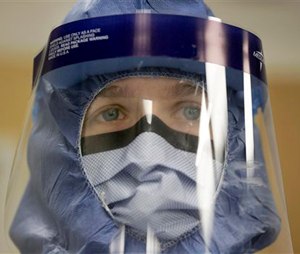 In this Oct. 16, 2014, file photo, Registered nurse Keene Roadman, stands fully dressed in personal protective equipment during a training class at the Rush University Medical Center, in Chicago. The Centers for Disease Control and Prevention released new guidelines Monday, Oct. 20, for how health workers should gear up to treat Ebola patients. (AP Photo/Charles Rex Arbogast, File)