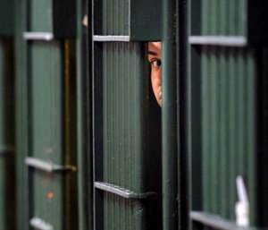 An inmate peaks through the bars at the restrictive housing unit, formerly known as solitary confinement, at the Men's Central Jail in Los Angeles. (Photo/Wally Skalij of Los Angeles Times via TNS)
