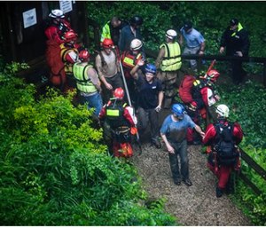 Rescued people exit Hidden River Cave after officials said over a dozen people who exploring the cave were trapped by rising water. (Austin Anthony/Daily News via AP)