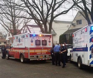 Emergency personnel gather near a home where police say four people were found dead in an apparent carbon monoxide poisoning in the Queens borough of New York on Friday, April 10, 2015. (AP Photo/Mike Balsamo)

