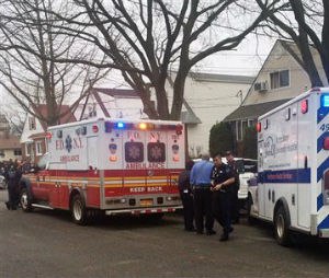 Emergency personnel gather near a home where police say four people were found dead in an apparent carbon monoxide poisoning in the Queens borough of New York on Friday, April 10, 2015. (AP Photo/Mike Balsamo)
