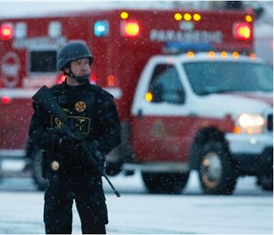 An officer stands guard near a Planned Parenthood clinic. A gunman opened fire at the clinic on Friday, authorities said, wounding multiple people. (AP Photo/David Zalubowski)