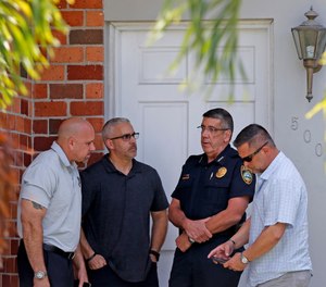 Surfside Chief of Police Julio Yero, second from right, speaks with investigators outside the home of Sol Pais, Wednesday, April 17, 2019, in Surfside, Fla. (Al Diaz/Miami Herald via AP)