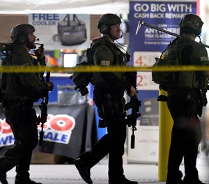 Heavily armed police officers exit the Costco following a shooting inside the wholesale warehouse in Corona, Calif. (Will Lester/Inland Valley Daily Bulletin/SCNG via AP)