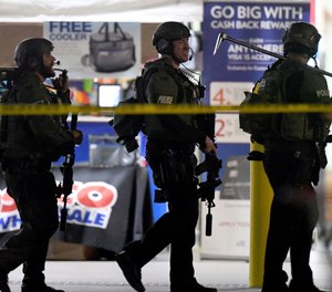 Heavily armed police officers exit the Costco following a shooting inside the wholesale warehouse in Corona, Calif. (Will Lester/Inland Valley Daily Bulletin/SCNG via AP)