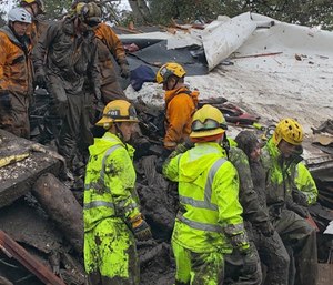A mud-covered girl is pulled free by firefighters after they cut their way into her home. (Photo/Santa Barbara County Fire Dept.) 
