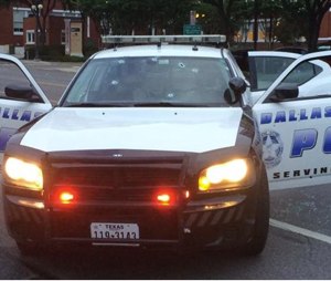 This photo sent via Twitter by the Dallas Police Department shows gunshot damage to a squad car Saturday. Police Chief David Brown says investigators believe the man acted alone in the early-morning attack on Dallas police headquarters. (Dallas Police Department, via AP)