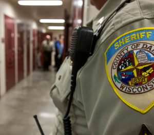 A deputy stands by as fellow deputies put an inmate with mental issues in an isolation cell in the Dane County Jail Tuesday, Sept. 16, 2014, in Madison, Wis.
