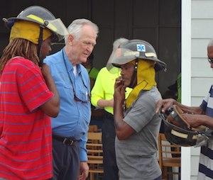 Philanthropist Ian Edgar (center) has thrown financial and political clout at getting a fire department established on Exuma. Below, IFRM volunteers select proper fitting gear for the new firefighters. (Photo: Rick Markley)