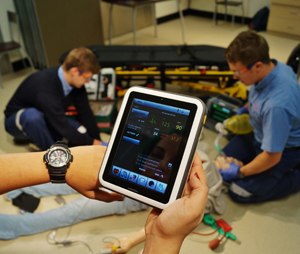 Close-up of watch and tablet screen during a simulation debriefing.