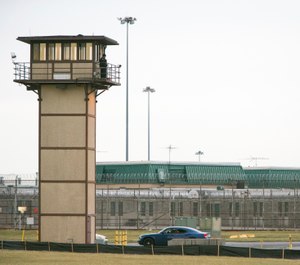 A prison guard stands on a tower during a hostage situation at James T. Vaughn Correctional Center in Smyrna, Del. The second in a series of trials for 18 inmates charged in a deadly Delaware prison riot began Monday, Jan. 14, 2019 (Suchat Pederson/The News Journal via AP, File)