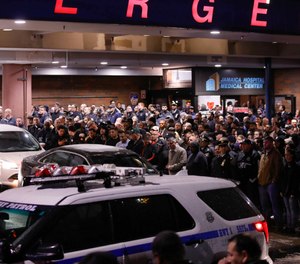 Officers salute a procession as the remains of slain Detective Brian Simonsen are removed from Jamaica Hospital Tuesday, Feb. 12, 2019, in the Queens borough of New York. A NYPD detective and a NYPD sergeant were shot while responding to an armed robbery at a T-Mobile store in Queens.