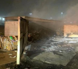 Modesto firefighters rescued a man locked inside a burning dumpster enclosure on Friday.