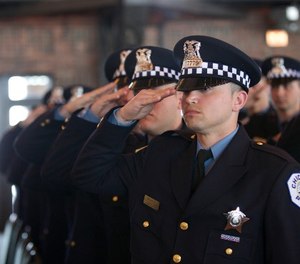 Police recruits salute during the playing of the National Anthem at the Chicago Police Department recruit graduation ceremony at Chicago’s Navy Pier Grand Ballroom March 30. Four Illinois National Guard Soldiers were among the 107 recruits that graduated, dedicating themselves to serving the community and the city of Chicago.