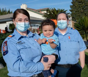 Hall Ambulance EMT Michelle Guidotti (left) and Paramedic Marian Anson reunited with baby Oliver at his adoption party one year after they delivered him.