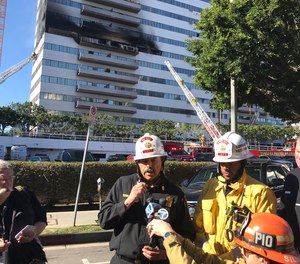 Los Angeles Fire Department Chief Ralph Terrazas speaks with reporters outside the high-rise apartment building where a fire broke out on the sixth floor, forcing firefighters to rescue residents from the 25th story rooftop.