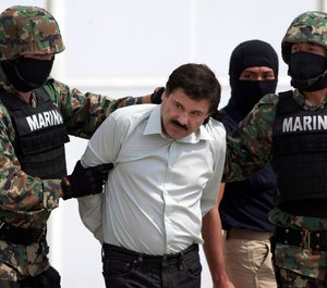 Joaquin "El Chapo" Guzman, center, is escorted to a helicopter in handcuffs by Mexican navy marines at a hanger in Mexico City, after he was captured overnight in the beach resort town of Mazatlan. (AP Photo/Eduardo Verdugo, File)
