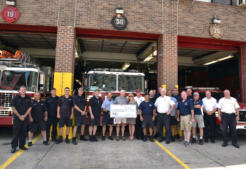 Members of Engine 50/Ladder 19 present a donation check to Building Homes for Heroes.