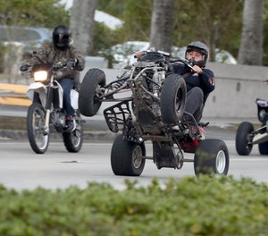 An ATV rider does a wheelie while riding in Miami Lakes on Monday, Jan. 21, 2019. The group caught the attention of BSO near Hallandale Beach Blvd. and Federal Hwy., but moved southwest, joining others and dipping into Miami Dade County. In recent years, ATVs and motorcycles have swarmed the streets in support of the 'Wheels Up, Guns Down' movement. (Amy Beth Bennett/South Florida Sun Sentinel/TNS)