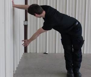 You can use any wall to perform this T-shaped rotational stretch. Work both sides.