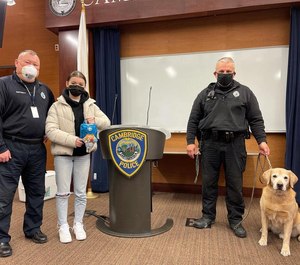 Weymouth High School senior Emily Martignetti presents the Cambridge Police Department with first-aid kits for its K-9 officers.