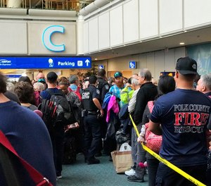 People wait to get through security at the Orlando International Airport following a security incident on Saturday, Feb. 2, 2019. Passengers on shuttles to gates at Florida's busiest airport had to be brought back for a second screening, bringing security checkpoints to a temporary standstill. A spokeswoman for Orlando International Airport told television station WKMG on Saturday that the passengers were returned in