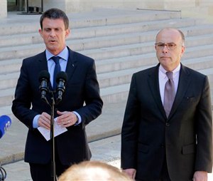 French Prime Minister Manuel Valls, left, and interior minister Bernard Cazeneuve, address the media after a cabinet meeting at the Elysee Palace in Paris, France, Wednesday, April 22, 2015. An Islamic extremist with an arsenal of heavy weapons planned an imminent attack on one or more French churches, France's top security official said Wednesday, announcing the arrest of the man who is also accused in the death of a young mother, Aurelie Chatelain, a 32-year-old Frenchwoman visiting Paris for a training session for her work.