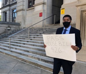 Lawyer Daniel Brown holds a poster calling on Georgia lawmakers to pass a state hate crimes law on Thursday, June 18, 2020 in Atlanta. (AP Photo/Jeff Amy)