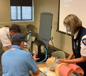 Major Jessica Ross teaches Lieutanant Wes Long and EMT Josh Helton learn to use the AHP 300, using the “see one, do one, teach one” method.