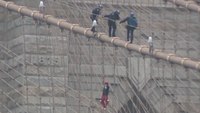 Watch: NYPD officers scale Brooklyn Bridge to coax down climber