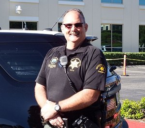 Deputy Chet Parker stands in front of his vehicle