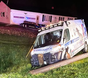 An ambulance carrying a 12-year-old patient crashed into a utility pole Monday night, causing power lines to fall onto the rig.