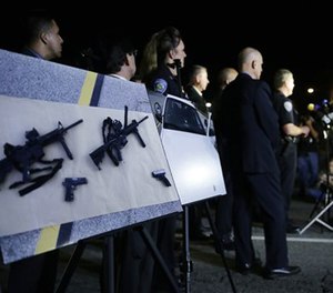 Police crime photos are displayed during a press conference near the site of yesterday's mass shooting on Thursday, Dec. 3, 2015.