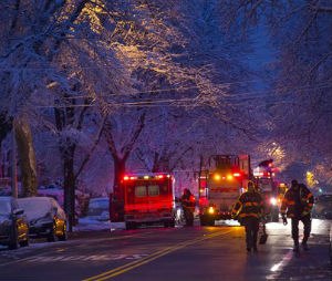 Firefighters walk near the scene of a fire, center left, in which seven children died in the Brooklyn borough of New York Saturday, March 21, 2015. (AP Photo/Craig Ruttle)