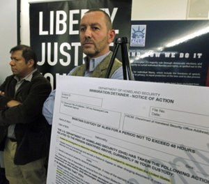 Lead plaintiff Duncan Roy, right, appears at a news conference to announce a federal lawsuit by the American Civil Liberties Union on behalf of arrestees who say they were denied bail because they had federal immigration holds.