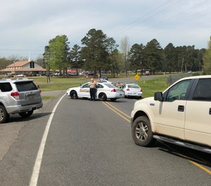 Auxiliary unit members volunteer at a funeral escort. After blocking intersections ahead of the escort, the lead cars block the highway at the entrance of the graveyard. Volunteers place their hand over their hearts until the whole procession enters the graveyard. (Photo/Marcel Livesay)