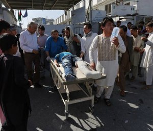 Afghans help an injured man at a hospital after an explosion struck a protest march, in Kabul, Afghanistan, Saturday, July 23, 2016.