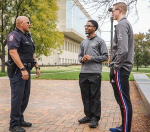 An IUPD officer talks with students on the IUPUI campus.