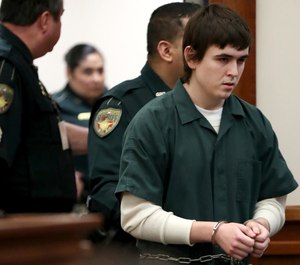 Dimitrios Pagourtzis, the Santa Fe High School student accused of killing 10 people in a May 18 shooting at the high school, is escorted by Galveston County Sheriff's Office deputies into the jury assembly room for a change of venue hearing at the Galveston County Courthouse in Galveston, Texas. (Jennifer Reynolds/The Galveston County Daily News via AP, Pool)