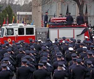 Firefighters stand at attention as the casket of fallen Philadelphia firefighter Joyce Craig is loaded onto Engine 64 following a funeral service in Philadelphia. (AP Photo/ Joseph Kaczmarek)