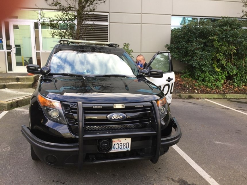In this photograph, the officer’s lower legs are exposed to ricochets under the car even though we can’t see them for direct targeting. The officer’s head and neck are exposed to bypasses (direct fire), as well as ricochets off the hood and windshield.