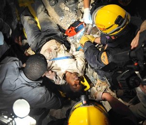 Members of the Los Angeles County Fire Department Search and Rescue Team rescue a Haitian woman from a collapsed building in downtown Port-au-Prince, Haiti, Jan. 17, 2010. The woman had been trapped in the building for five days without food or water.
