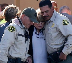 Los Angeles Sheriff's Department and medical personnel comfort each other outside the Antelope Valley Medical Center after the fatal shooting of a deputy in Lancaster, Calif. on Oct. 5.