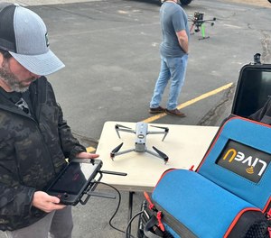 An attendee at the Law Enforcement Drone Association's 2023 annual conference prepares to stream video from a drone using LiveU technology.