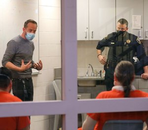 Nate Lanthrum, clinical director of Lighthouse Recovery, leads a group session for recovering addicts living in the recovery pod at the Kane County Jail on April 20, 2021. Looking on is Kane County Sheriff Ron Hain, right.
