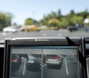In this Sept.17, 2014 file photo a police vehicle reads the license plates of cars in a parking lot in San Marcos, Calif.